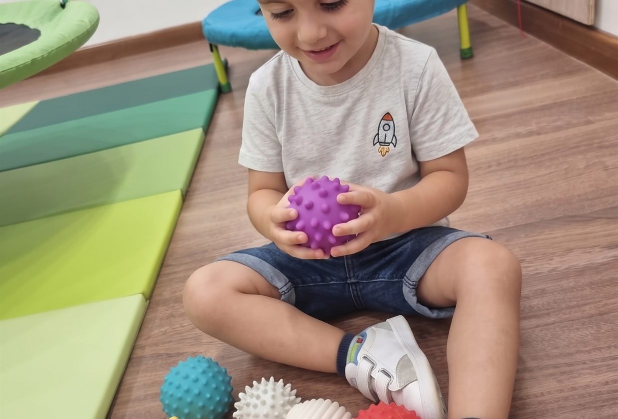 Un niño pequeño jugando con pelotas sensoriales